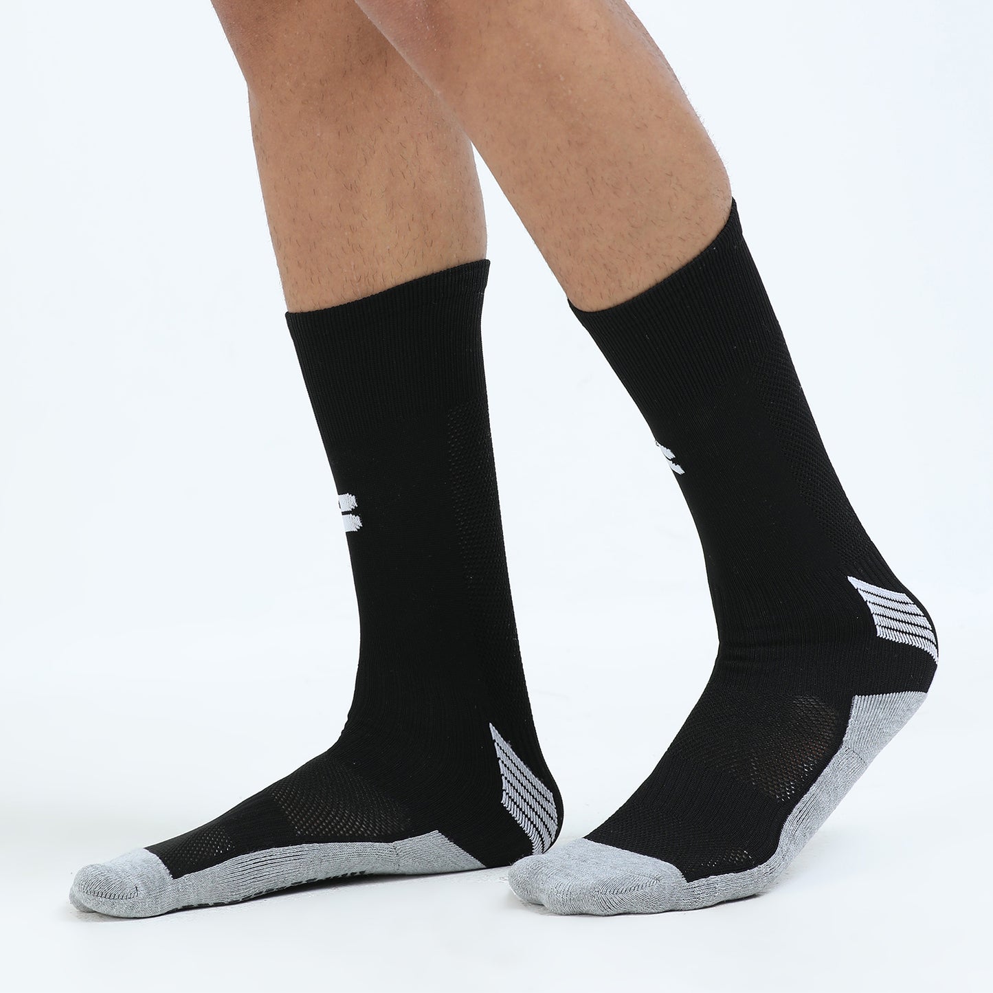 Black socks with gray toes and heels worn by a person on a white background
