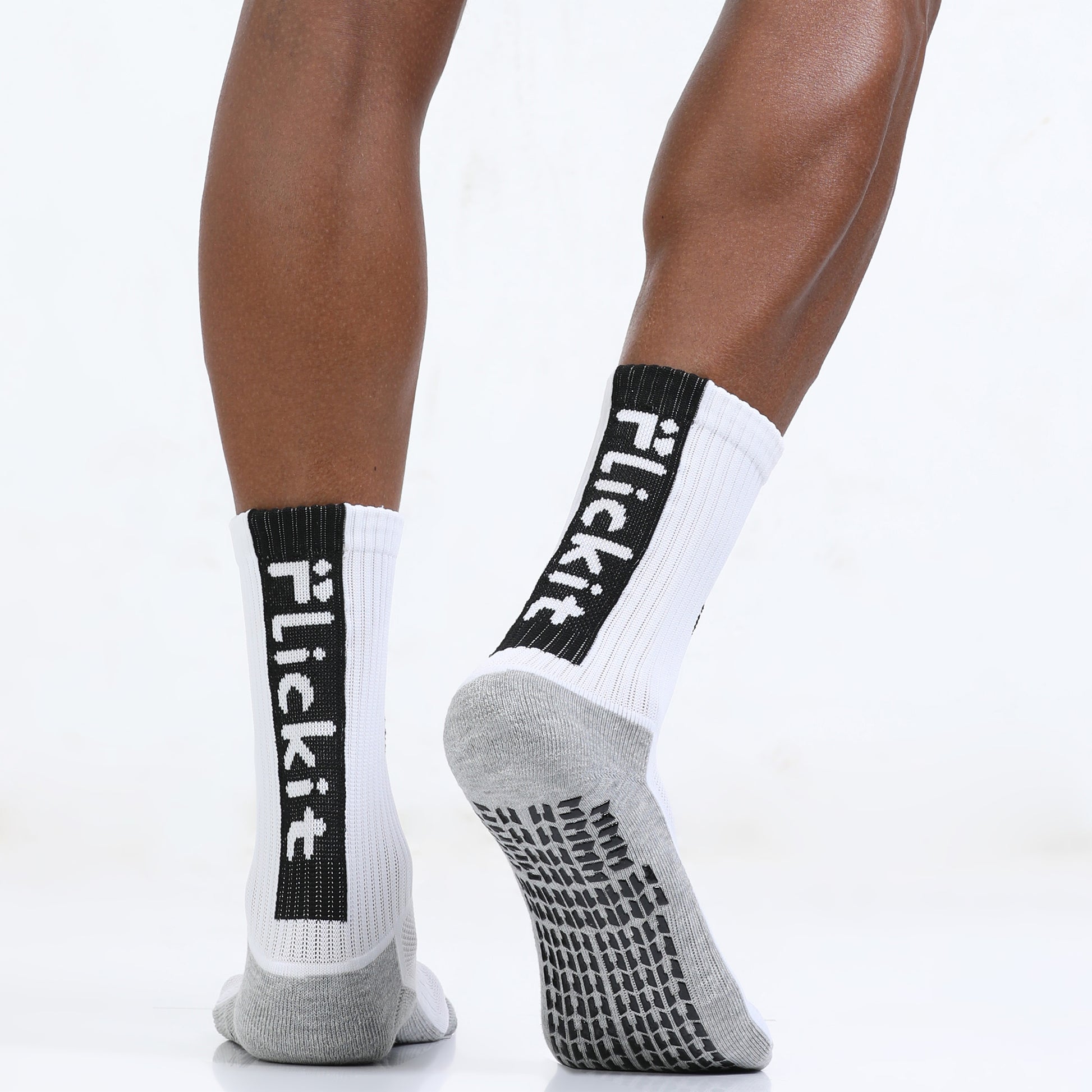 White socks with black text and gray toes worn by a person on a white background