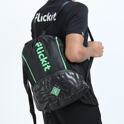 Person holding a black backpack with green accents and 'Flickit' branding on a light gray background