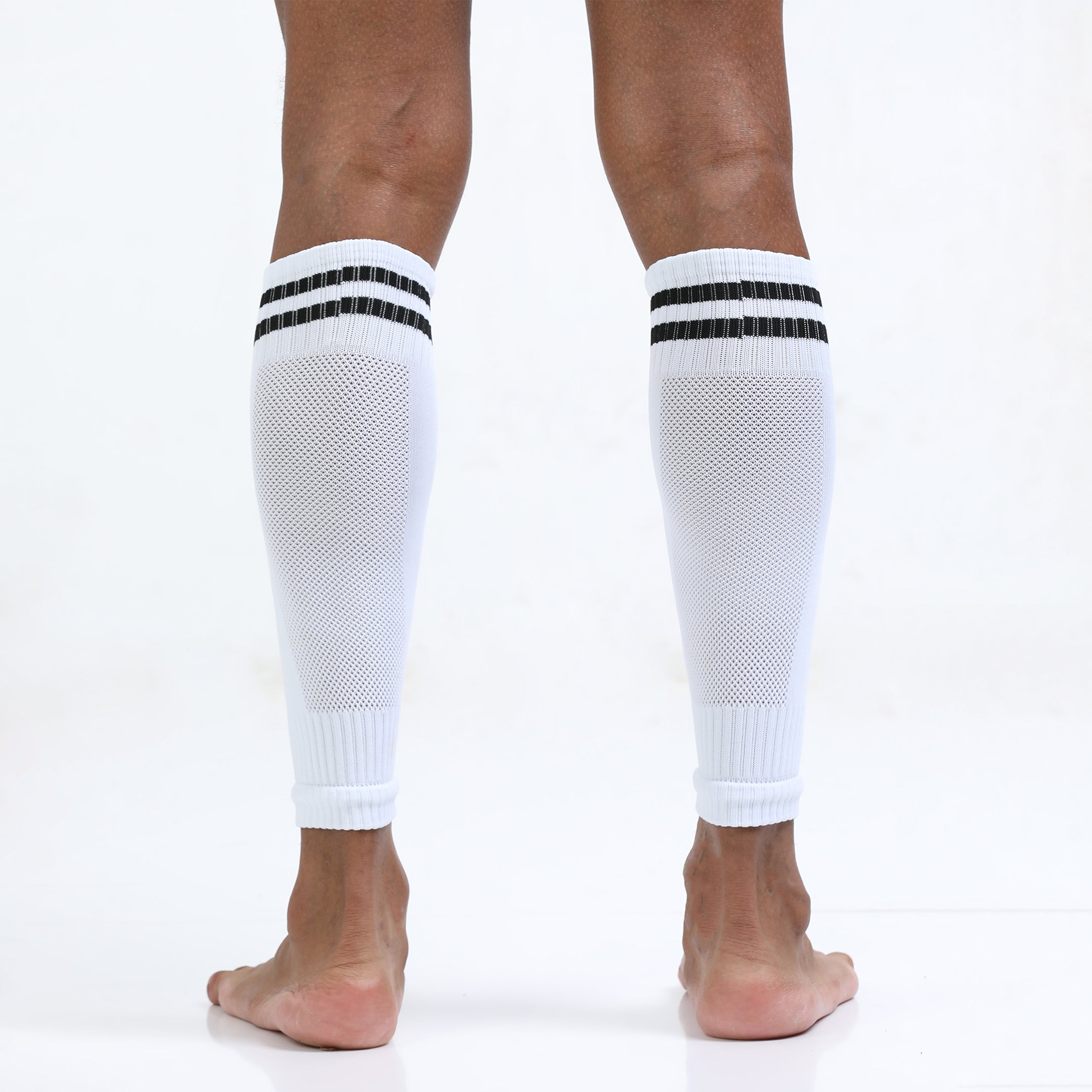 White knee-high socks with black stripes worn by a person on a white background