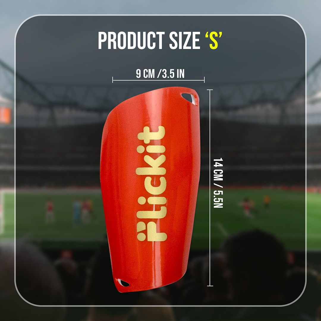 Red shin guard with 'Flickit' branding and measurements on a blurred stadium background
