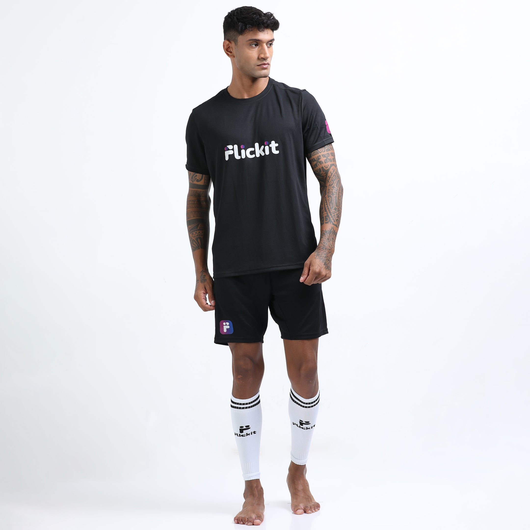 Man wearing a black 'Flickit' t-shirt and shorts on a white background